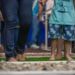 Criança caminhando de mãos dadas com adulto, descalços pelo Jardim Sensorial